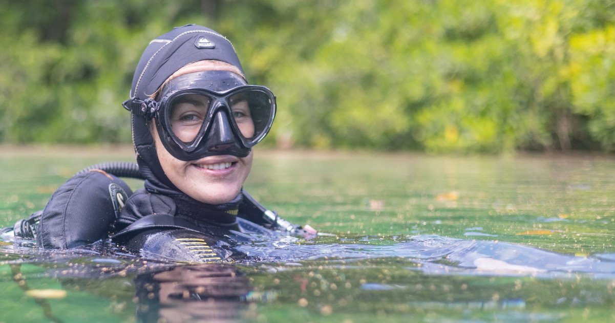 plongee-francophone-tulum-monitrice-cenote Monitrice française de plongée souriante à la surface d’un cénote vert émeraude à Tulum